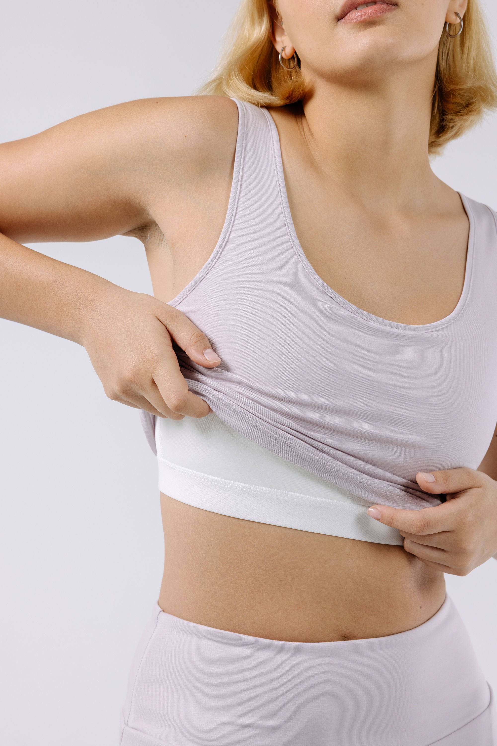 Woman wearing a lavender pajama crop top with a built-in bra against a plain background.
