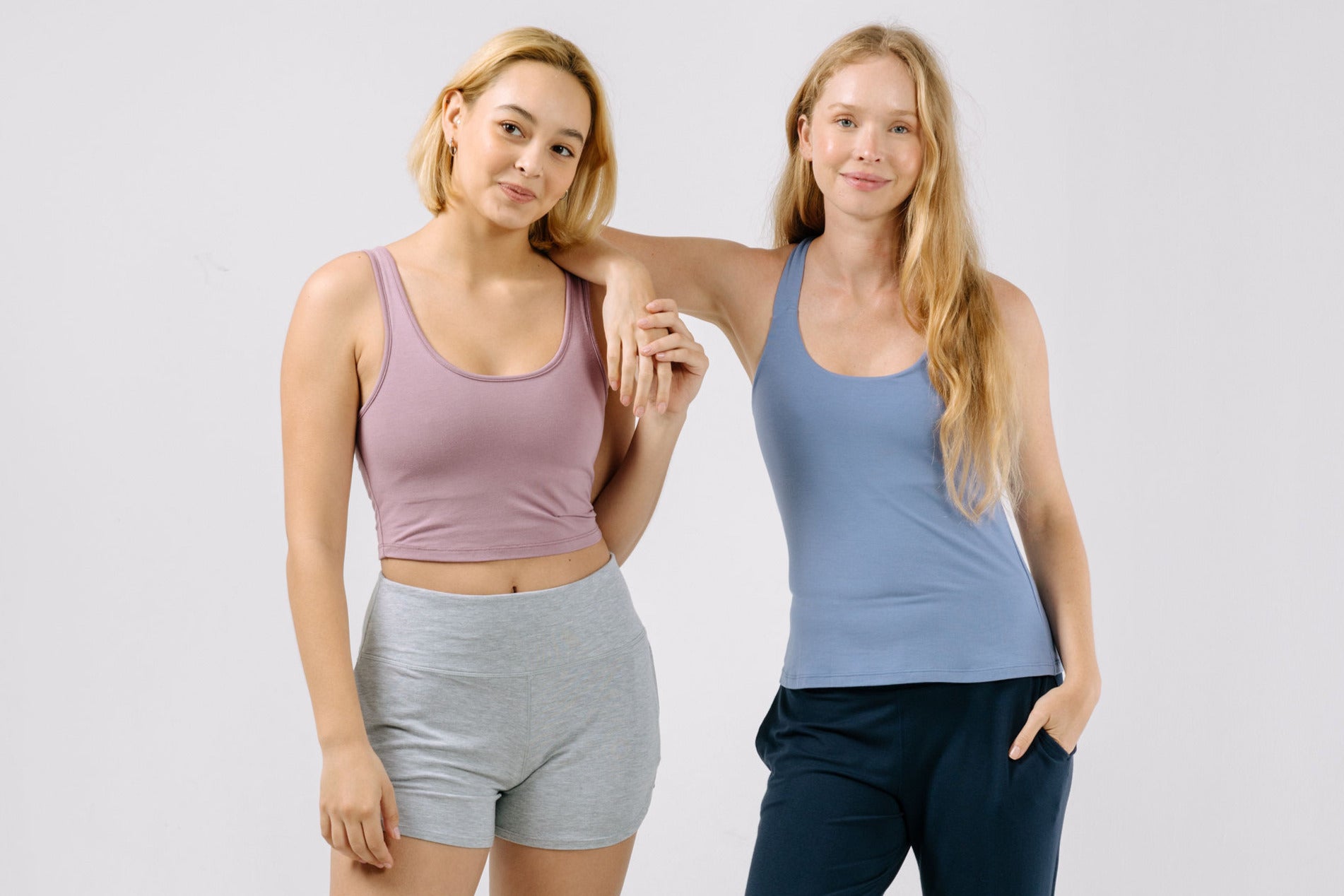 Two women wearing mix-and-match pajamas standing against a plain background.