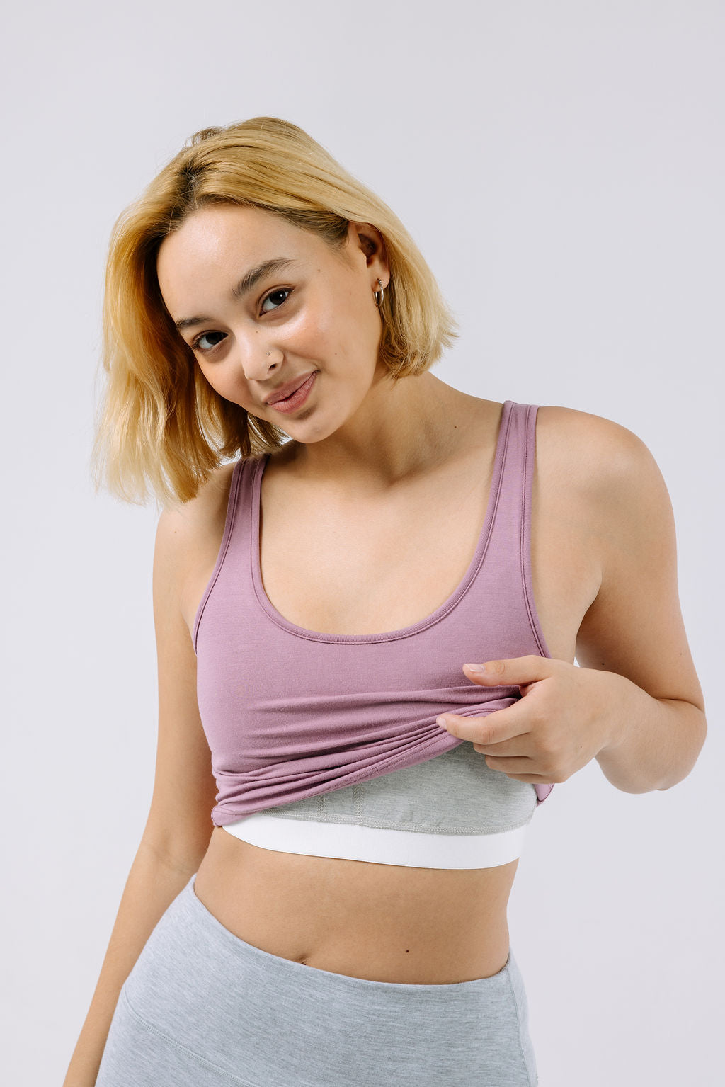 Woman wearing a dusty lilac pajama crop top with a built-in bra. 