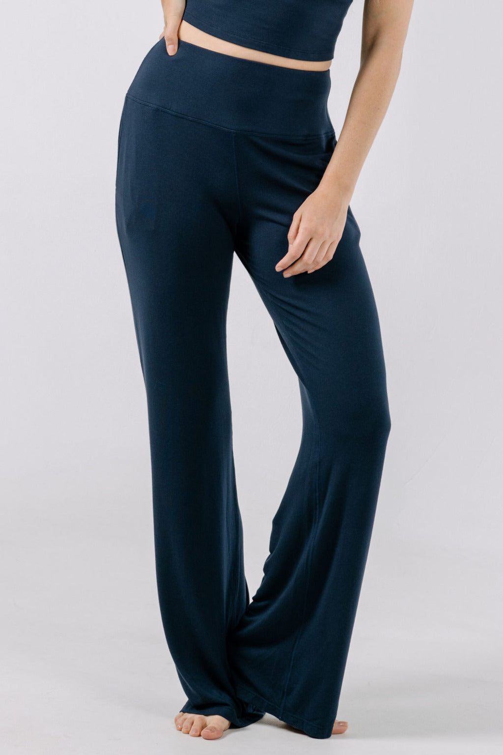 Navy blue wide-leg pajama pants worn by a person on a light gray background.